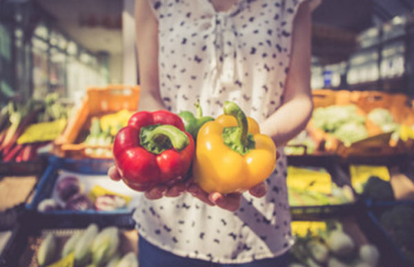 Женщина в магазине держит две перчинки